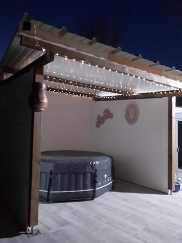 a bed under a canopy with lights on it at Le Coin Charmant - vue montagnes et jacuzzi privé in Privas