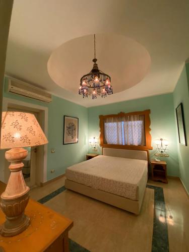 a bedroom with a bed and a chandelier at Domina Coral Bay Resort in Sharm El Sheikh