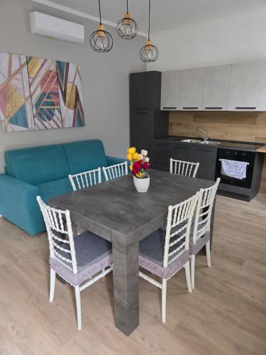 a dining room table with chairs and a blue couch at dream garden appartamento in Scafati