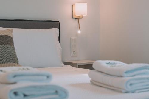 a hotel room with a bed with towels on it at Aura Apartment - next to the beach of Ayia Anna in Kría Vrísi