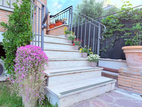 a set of stairs with potted plants and flowers at B&B La Fenice Roma - Fiumicino in Rome