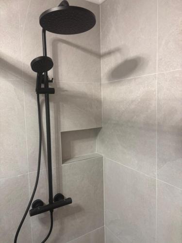 a shower with a black lamp in a bathroom at Magnhilds Luxury Apartment in Otta