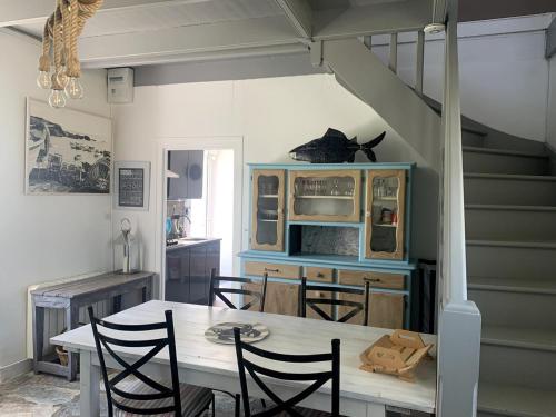 une cuisine avec une table et des chaises ainsi qu'un escalier dans l'établissement Maison de pêcheur à Locquirec, plage à 600M, à Locquirec