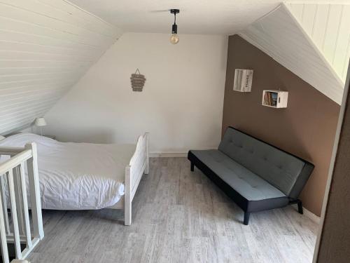 - une chambre mansardée avec un lit et un banc dans l'établissement Maison de pêcheur à Locquirec, plage à 600M, à Locquirec