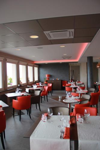 a dining room with tables and red chairs at Hôtel Restaurant le Panorama in Évian-les-Bains