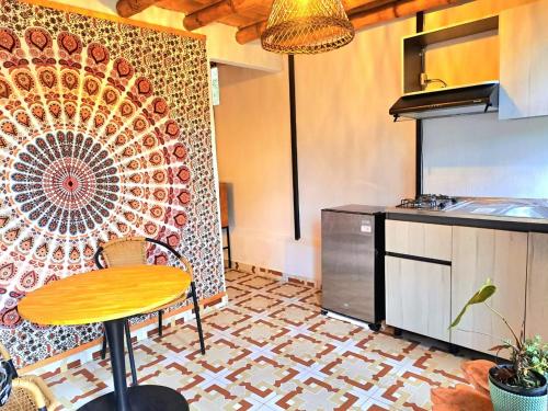 a kitchen with a table and a mosaic wall at Hotel Marrokos Aeropuerto José María Córdova in Rionegro