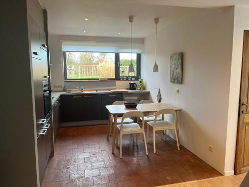 a kitchen with a table and chairs in a kitchen at Un Temps Pour Vous in Modave