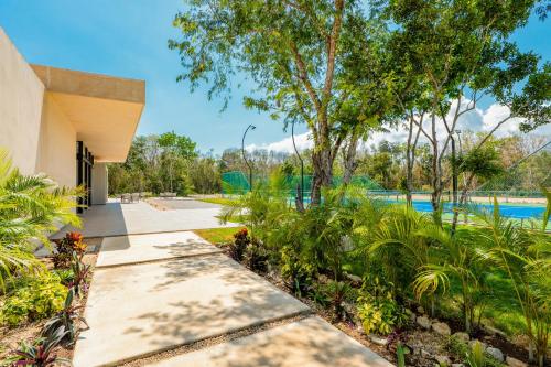an exterior view of a pool with trees and plants at Casa Jaguar in Xpu Ha