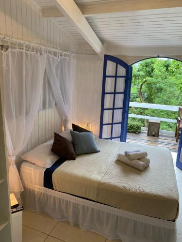 a bedroom with a bed with towels on it at BOSQUE TOQUE TOQUE Pousada in São Sebastião