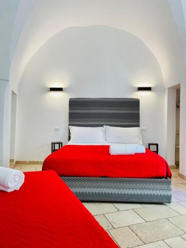a bedroom with a red bed with a red blanket at B&B Salentus in Gallipoli