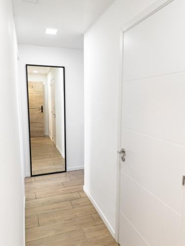 un couloir vide avec une porte et un miroir dans l'établissement Appartement Charmant Plage à pied, à Fréjus