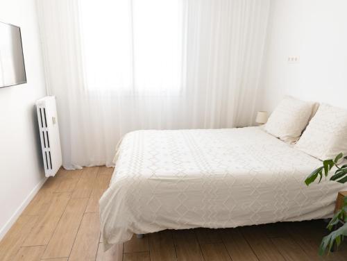 une chambre blanche avec un lit et une fenêtre dans l'établissement Appartement Charmant Plage à pied, à Fréjus