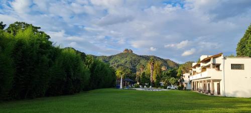 a large yard with a building and a mountain at Hotel Espacio Mágico in Tepoztlán