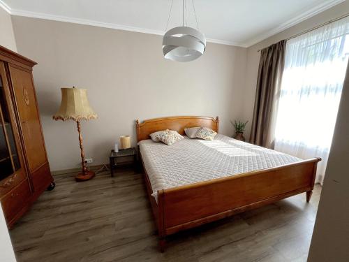 a bedroom with a bed and a lamp and a window at Villa Nelma in Ventspils