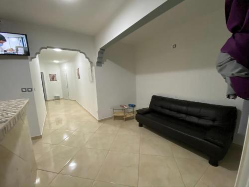 a living room with a black couch and a tv at Residence Mont Vernon II - B in Cul de Sac