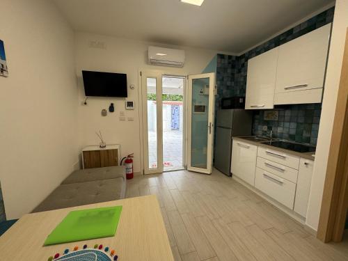 Una cocina con gabinetes blancos y una mesa en ella. en Casa Vacanza Blu, en Campomarino