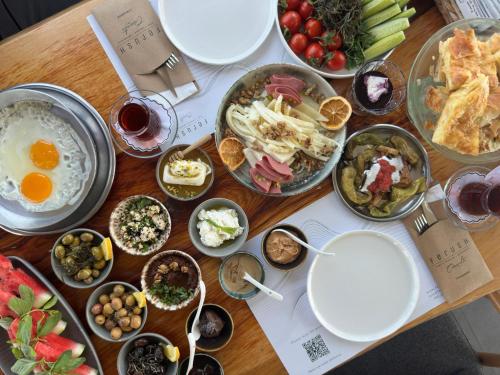 a wooden table with plates of food on it at Ferush Boutique Hotel in Urla