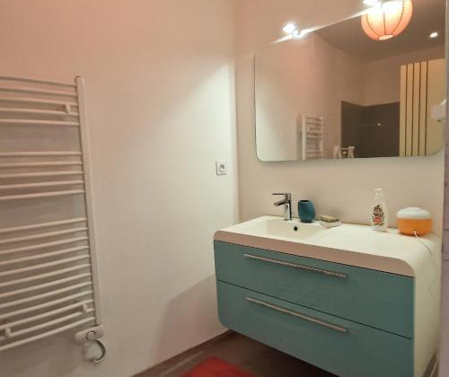 ein Badezimmer mit Waschbecken und Spiegel in der Unterkunft Kaze Océane in Brétignolles-sur-Mer