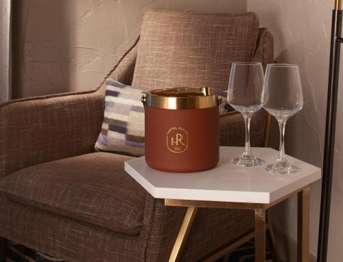 a bucket on a table next to two wine glasses at Hotel Royer Urbana Champaign, Tapestry Collection by Hilton in Champaign