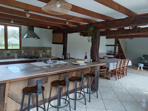 une cuisine avec un grand îlot et des tabourets de bar dans l'établissement Maison Normande La Bacane, à Lieurey