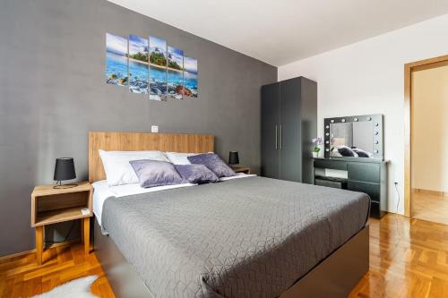 een slaapkamer met een groot bed met paarse kussens bij Apartment DP in Pula