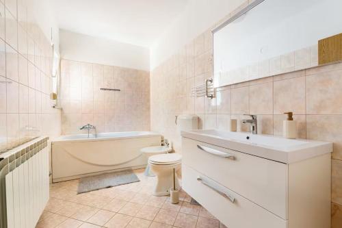 een badkamer met een bad, een toilet en een wastafel bij Apartment DP in Pula