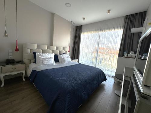 a bedroom with a bed and a large window at Ferush Boutique Hotel in Urla