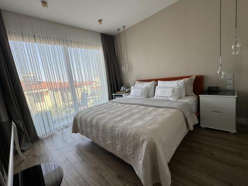 a bedroom with a large bed and a large window at Ferush Boutique Hotel in Urla