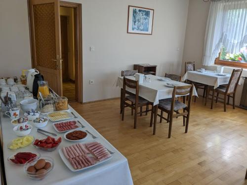 a table with food on it with tables and chairs at Gründner Vendégház in Siófok