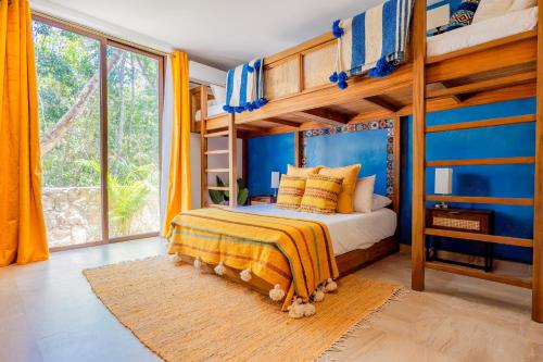 ein Schlafzimmer mit einem Etagenbett mit gelben und blauen Wänden in der Unterkunft Casa Jaguar Villa 1 in Playa del Carmen