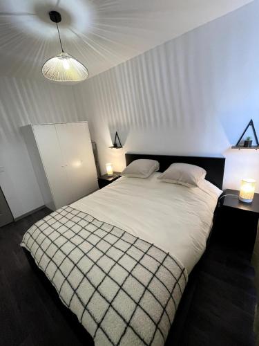 une chambre avec un grand lit blanc avec deux lampes dans l'établissement Apartment 2, à Nogent-sur-Oise
