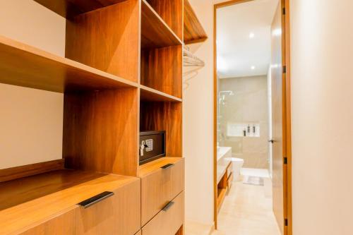 ein Badezimmer mit einem Fernseher in einem Holzschrank in der Unterkunft Casa Jaguar Villa 1 in Playa del Carmen