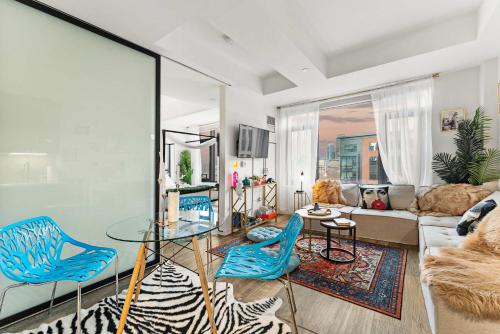 Una sala de estar con una mesa de cristal y sillas azules. en South End Gem City Views Rooftop Pool, en Boston