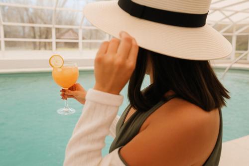 a woman wearing a hat holding a drink at Valle Andino in Uspallata