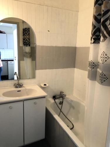 une salle de bain avec un lavabo, une baignoire et un miroir dans l'établissement Résidence Christiania - APPARTEMENT ALPE D'HUEZ QUARTIER BERGERS MAE-2191, à Huez