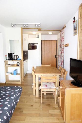 Cette chambre comprend une table à manger et une cuisine. dans l'établissement Résidence Christiania - APPARTEMENT ALPE D'HUEZ QUARTIER BERGERS MAE-2211, à Huez