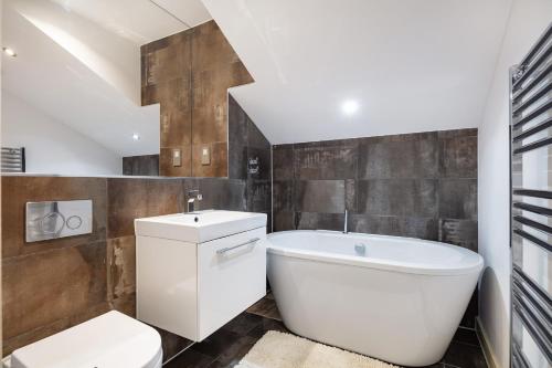 a bathroom with a tub and a toilet and a sink at 2 bed 2 bath Penthouse,terrace,London Eye,sleeps 6 in London