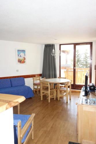 un salon avec un canapé bleu et une table dans l'établissement Résidence Christiania - APPARTEMENT ALPE D'HUEZ QUARTIER BERGERS MAE-2571, à Huez