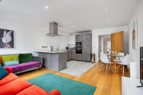 a living room with a purple couch and a kitchen at 2 bed 2 bath Penthouse,terrace,London Eye,sleeps 6 in London