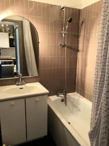 une salle de bain avec un lavabo, une baignoire et un miroir dans l'établissement Résidence Christiania - APPARTEMENT ALPE D'HUEZ QUARTIER BERGERS MAE-2871, à Huez