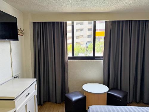 a hotel room with a table and a window at Hotel Faro in Mexico City