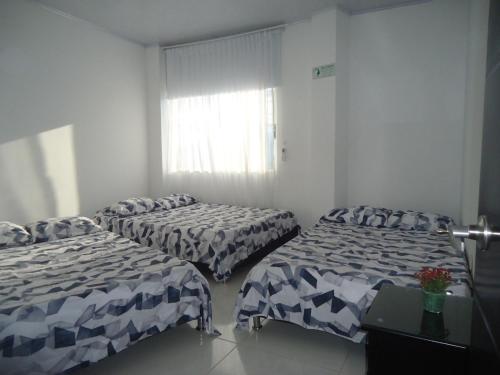 a room with two beds and a window at Finca Hotel Villa el Ocaso Huila in Rivera