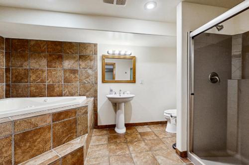 a bathroom with a tub and a sink and a toilet at McAbu House in McCall