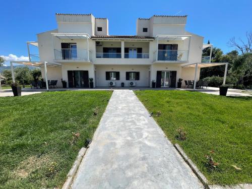 a large white house with a grassy yard at Villa Rodelia in Roda