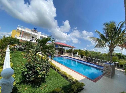 a house with a swimming pool in front of a house at Finca Hotel Villa el Ocaso Huila in Rivera