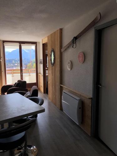 une chambre avec une table et des chaises et une chambre avec une fenêtre dans l'établissement Résidence Christiania - APPARTEMENT ALPE D'HUEZ QUARTIER BERGERS MAE-3091, à Huez