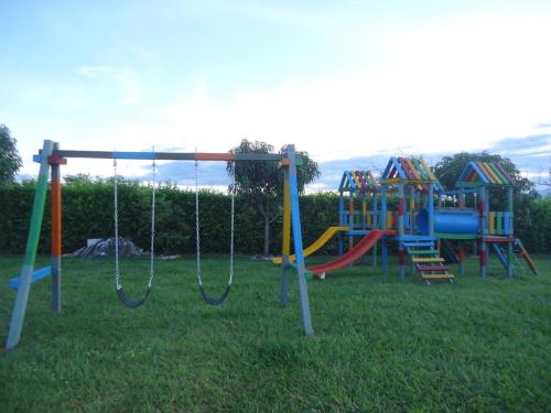 a playground with a swing set in the grass at Finca Hotel Villa el Ocaso Huila in Rivera