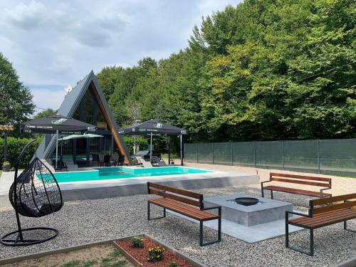 a patio with benches and a pool with an umbrella at Vikendica Sofijina Luka in Slatina Varoš