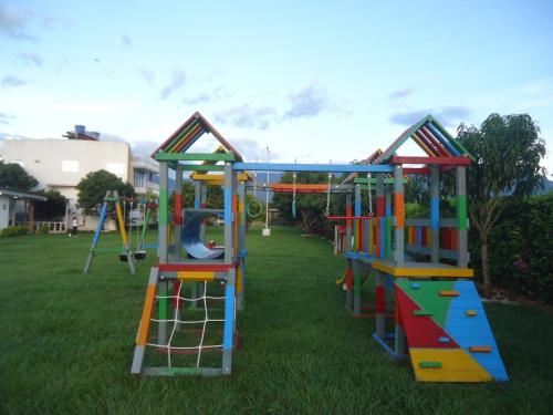 a playground with colorful equipment on the grass at Finca Hotel Villa el Ocaso Huila in Rivera