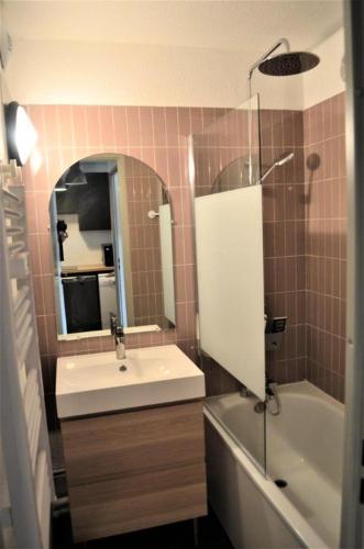 une salle de bain avec un lavabo, une baignoire et un miroir dans l'établissement Résidence Christiania - APPARTEMENT ALPE D'HUEZ QUARTIER BERGERS MAE-3181, à Huez